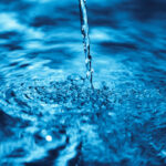 Close up of water falling on transparent water surface